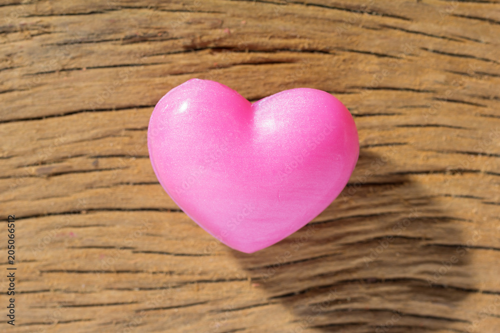 Red heart shape over wooden table. Overhead of romantic symbol of valentine day for background use. Concept of love, romance, and passion. Red heart shape over wooden table. Overhead of romantic symbol of valentine day for background use. Concept of love, romance, and passion.