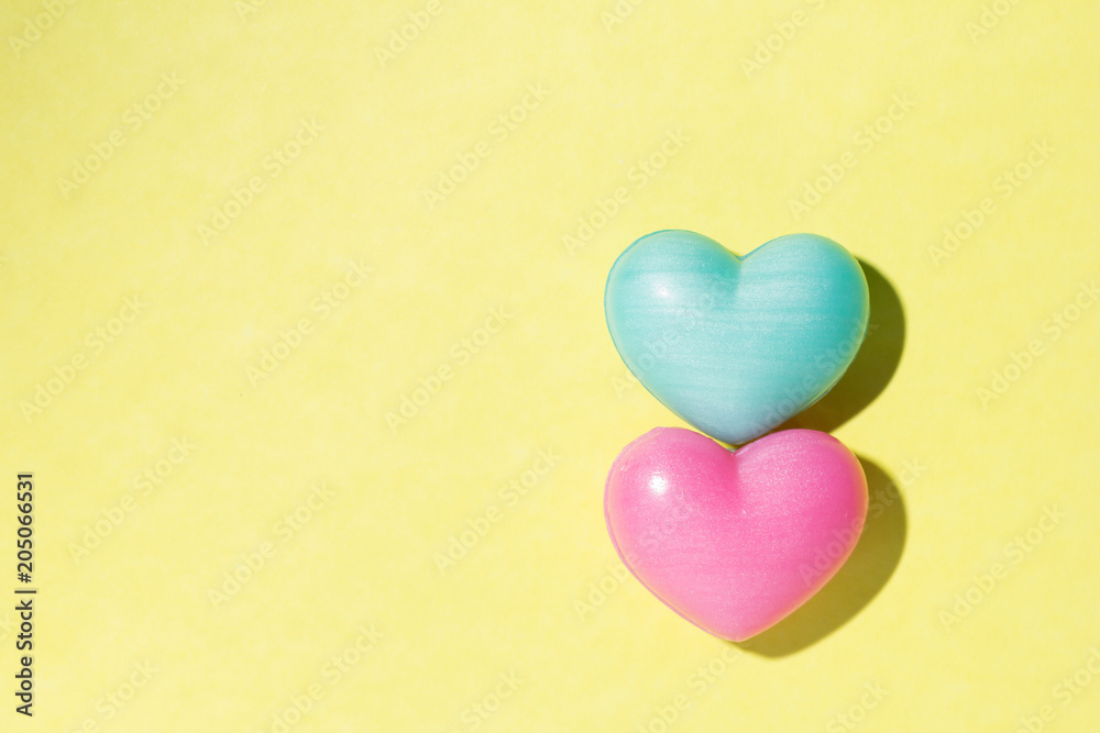 Couple of heart shapes over yellow table. Valentines day symbol for background use. Love, romance, and passion.
