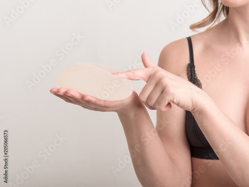 Young woman touch her breast implant before surgery.