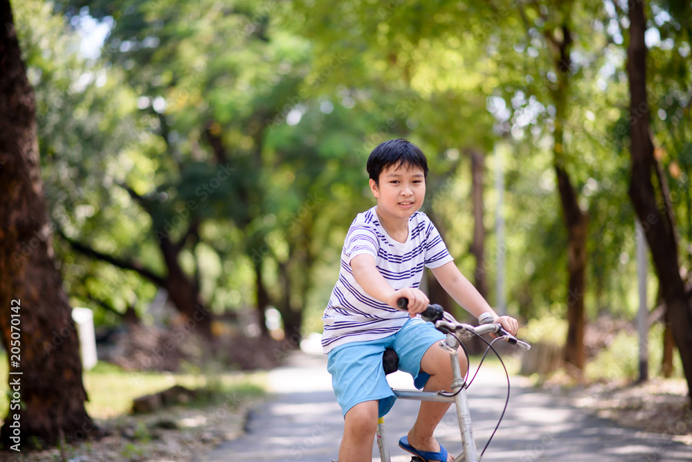 Asian boy ride bicycle in a park Asian boy ride bicycle in a park
