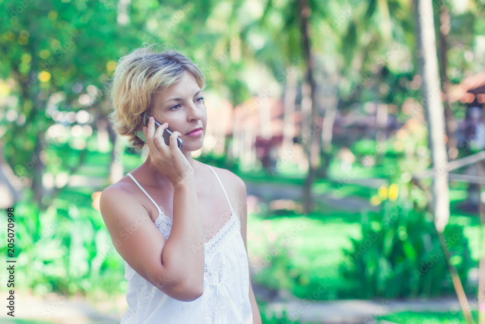 Portrait of a beautiful smiling woman using a mobile phone outdoors Portrait of a beautiful smiling woman using a mobile phone outdoors