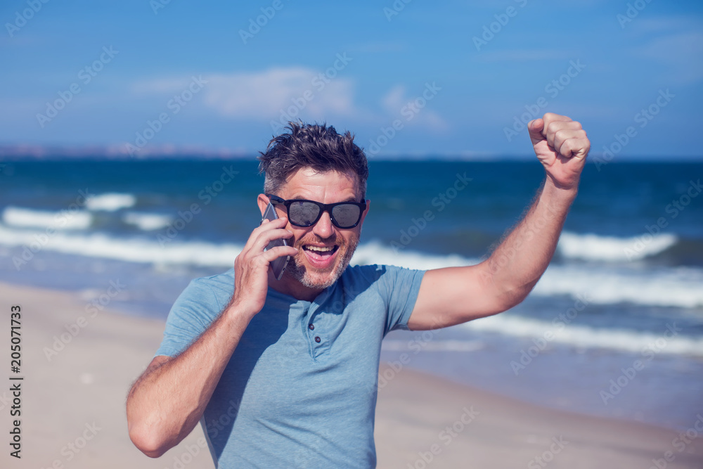 Young man using smartphone on the beach