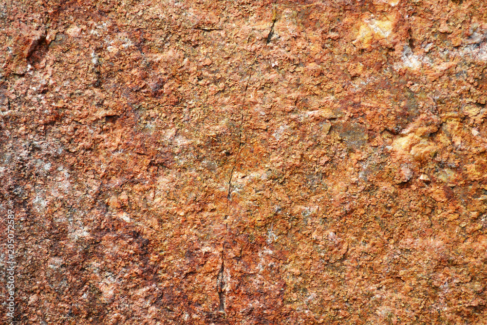Pattern of surface of a red stone. Texture of stone in a natural environment. A granite stone Pattern of surface of a red stone. Texture of stone in a natural environment. A granite stone