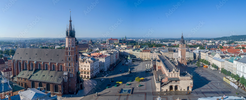 Fototapeta premium Aerial panorama of Krakow old city, Poland. Main Market Square (Rynek), old cloth hall (Sukiennice), town hall tower, St. Mary church (Mariacki), renovated Mickiewicz statue and far view of Wawel
