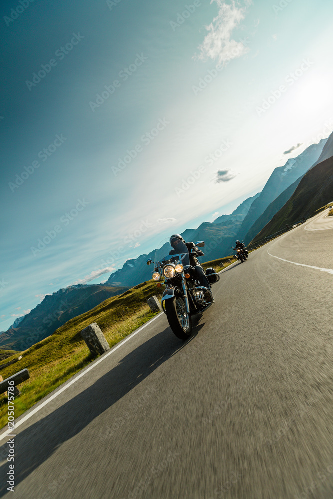 Obraz premium Motorcycle driver riding japanese high power cruiser in Alpine highway on famous Hochalpenstrasse, Austria.