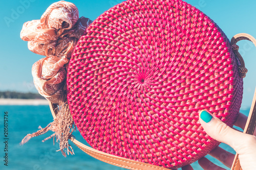 Woman with fashionable stylish rattan bag outside. Tropical island of Bali, Indonesia. Rattan and silk. photo