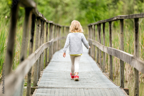Bambina che cammina sul ponte photo
