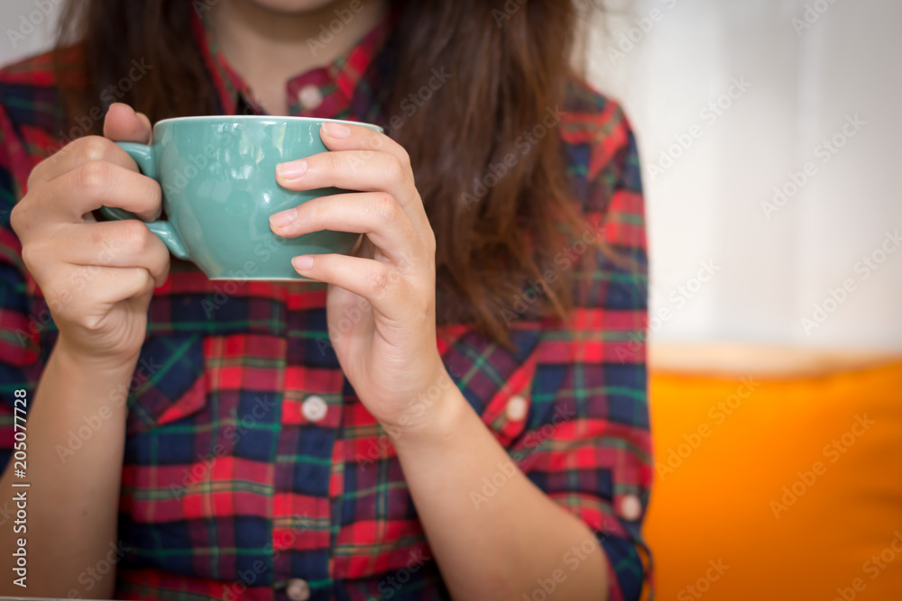 Woman holding a cup of coffee Woman holding a cup of coffee