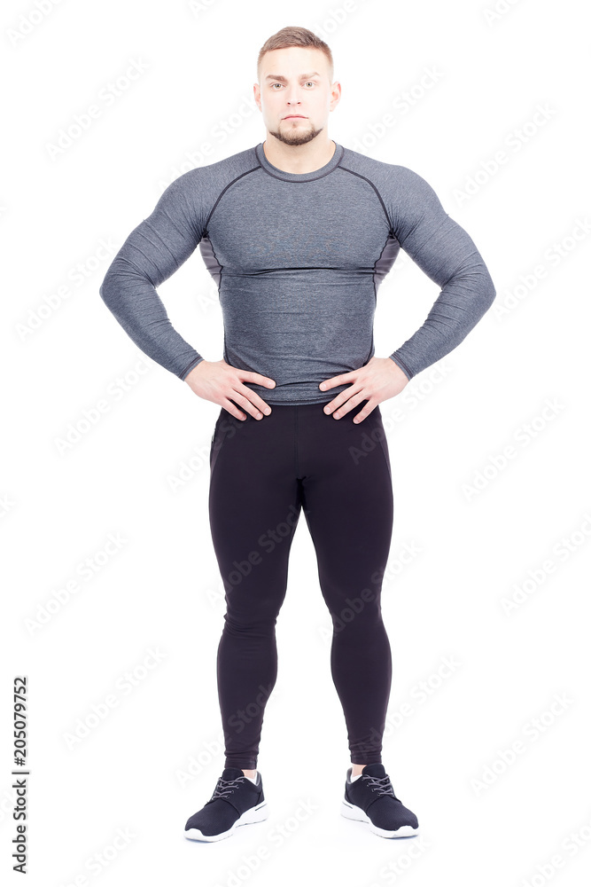 Portrait of handsome well-muscled gym instructor in sports tights and rashguard posing on white background Portrait of handsome well-muscled gym instructor in sports tights and rashguard posing on white background