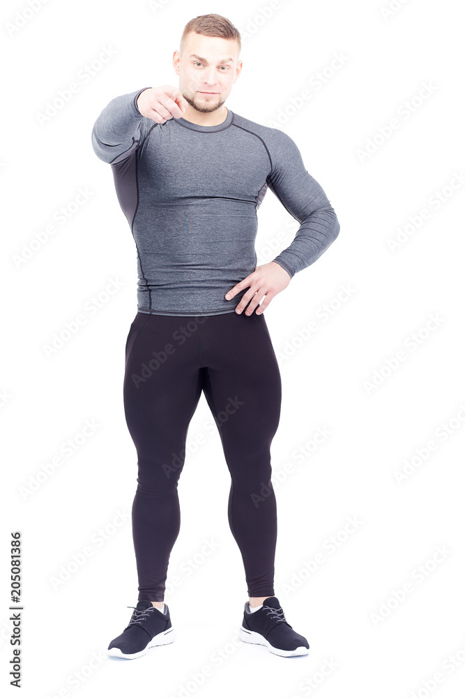 Portrait of handsome well-muscled gym instructor in sports tights and rashguard posing on white background Portrait of handsome well-muscled gym instructor in sports tights and rashguard posing on white background