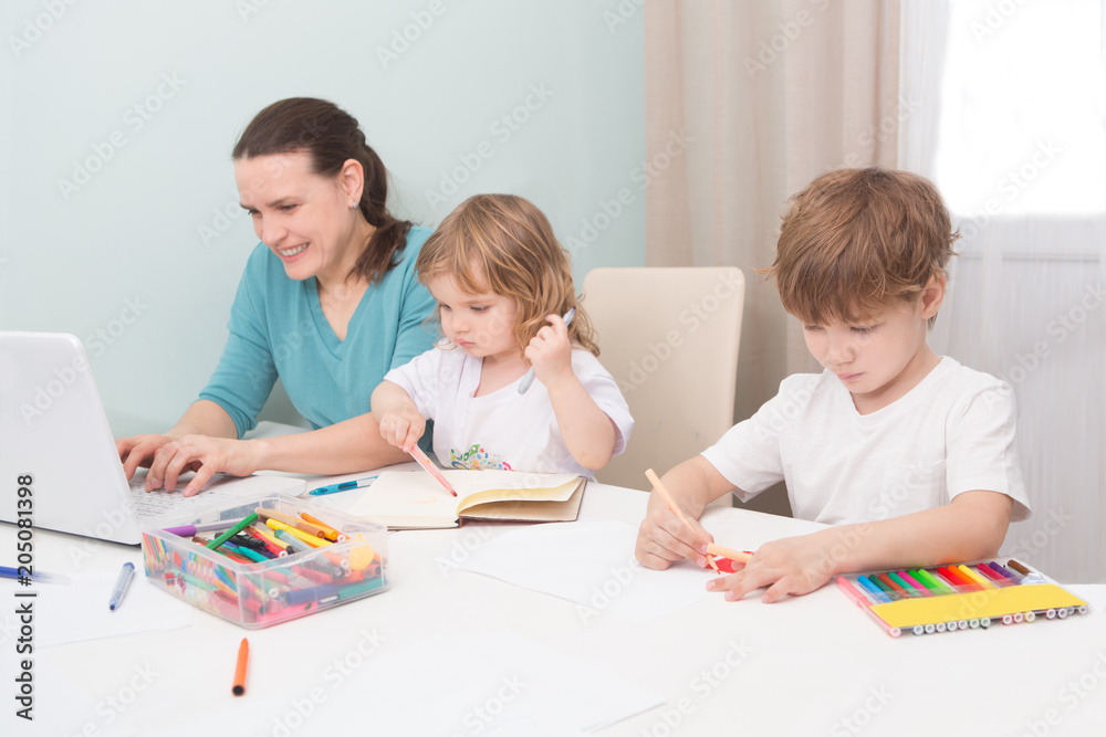 A mother working at home and parenting her two children.
A mother working at home and parenting her two children.