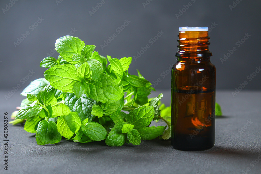 Fresh homemade green peppermint and butter in a glass small bottle on a gray dark concrete table. Fresh homemade green peppermint and butter in a glass small bottle on a gray dark concrete table.