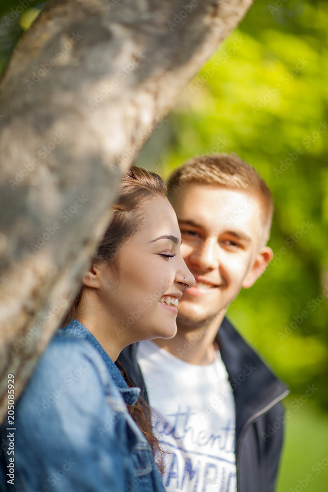 Young couple having fun, talking, flirting in a sunny park in springtime, beautiful, romantic mood Young couple having fun, talking, flirting in a sunny park in springtime, beautiful, romantic mood