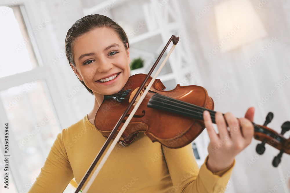 So pleased. Beautiful female enjoying her hobby and holding violin near neck So pleased. Beautiful female enjoying her hobby and holding violin near neck