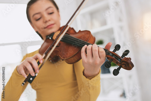 Conscious violinist. Delighted girl being relaxed while playing favorite melody