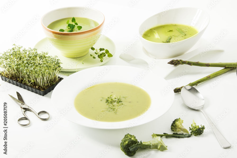 Broccolicreme-Suppe mit frischer Kresse, Spargelcreme-Suppe und Kräutersuppe auf weissem Hintergrund Broccolicreme-Suppe mit frischer Kresse, Spargelcreme-Suppe und Kräutersuppe auf weissem Hintergrund
