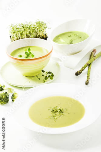 Broccolicreme-Suppe mit frischer Kresse, Spargelcreme-Suppe und Kräutersuppe auf weissem Hintergrund