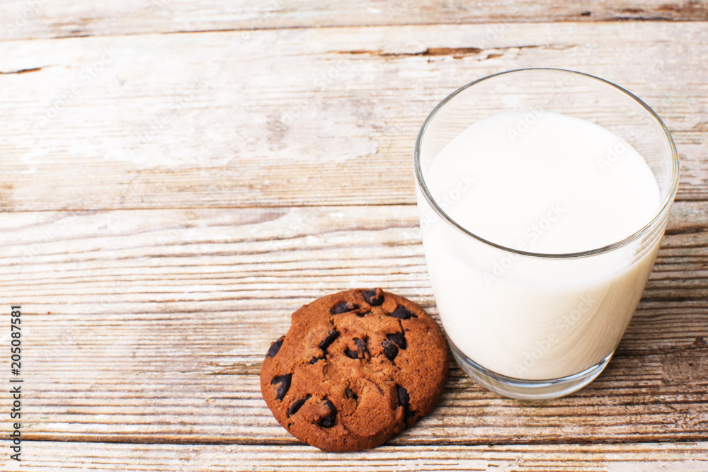 chocolate chip cookies and a glass of milk on an old board, top view chocolate chip cookies and a glass of milk on an old board, top view