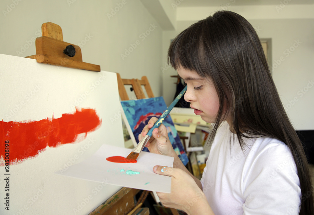 Naklejka premium Cute little girl is painting picture