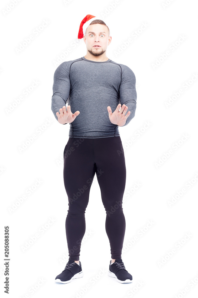Naklejka premium Portrait of athletic man wearing sports clothes and Santa hat