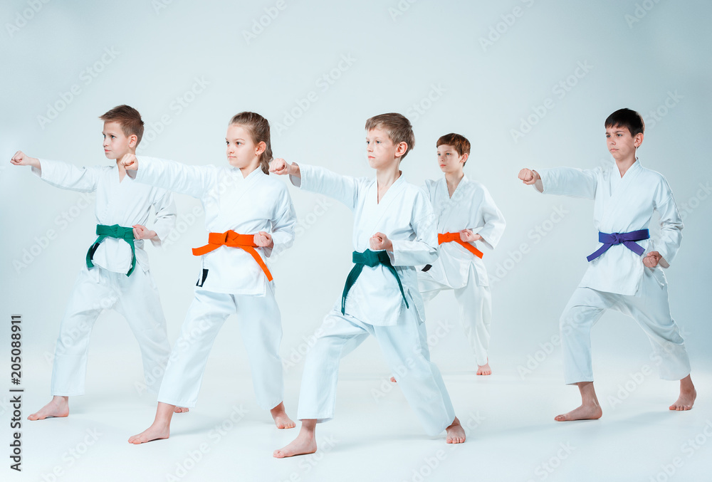 The group of boys and girl fighting at Aikido training in martial arts school. Healthy lifestyle and sports concept The group of boys and girl fighting at Aikido training in martial arts school. Healthy lifestyle and sports concept