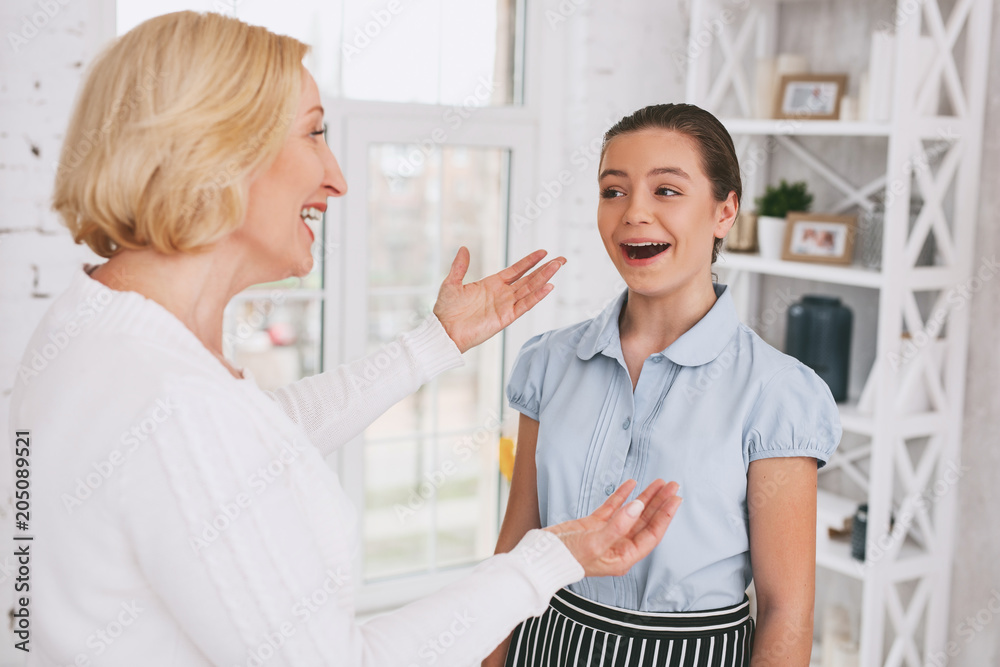 Nice to meet you. Joyful girl keeping smile on her face while looking at her tutor