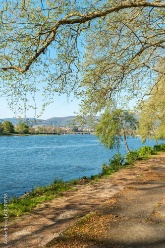 Park bench in river side view in nature landscape, Ponte de Lima, Portugal. photo