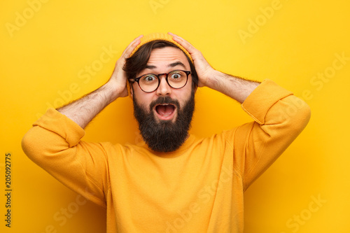 Bearded astonished man on yellow