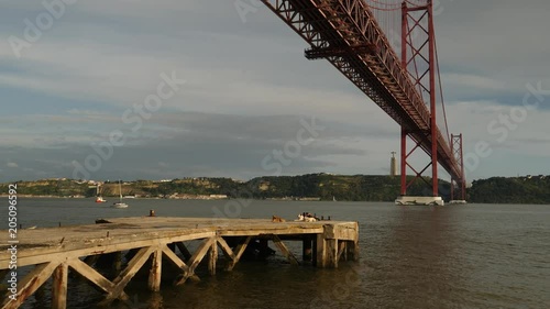 Walking underneath bridge 'Ponte 25 de Abril' and Taag river, Lisbon. photo