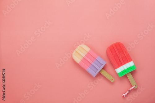 Table top view aerial image of food for summer holiday background concept.Flat lay arrangement variety ice cream pop stick on modern rustic pink paper wallpaper at office desk.Pastel tone design.