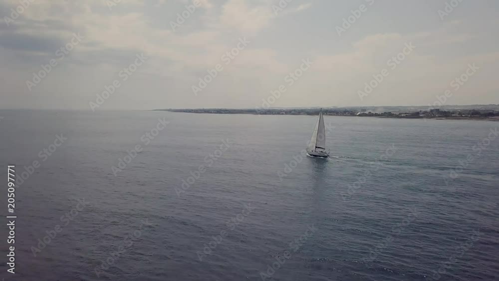 Aerial rising up view of a sailing boat along the coastline Aerial rising up view of a sailing boat along the coastline