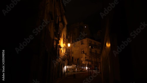 Alley on hill at night with carlights appearing, Alfama district in Lisbon. photo