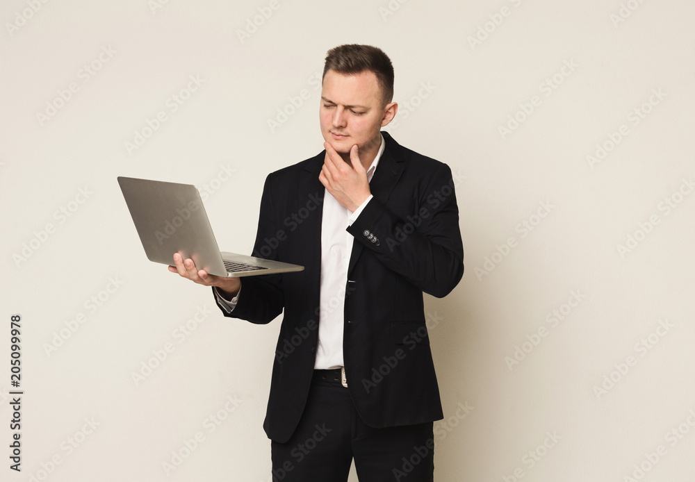 Pensive young caucasian businessman using laptop Pensive young caucasian businessman using laptop