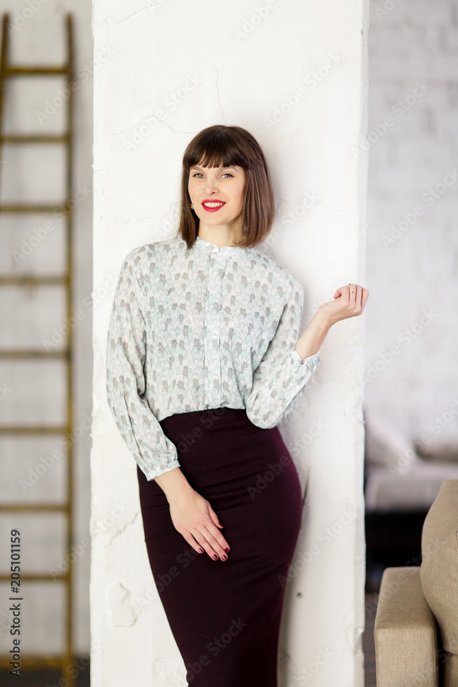 Photo of young brunette in blouse near wall