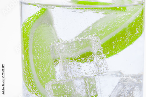 Pieces of fresh juicy lime sink into clear water.