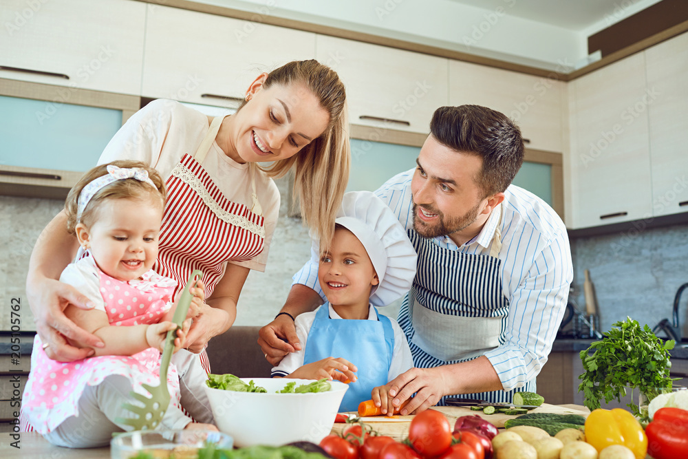 A happy family is preparing vegetables in the kitchen.