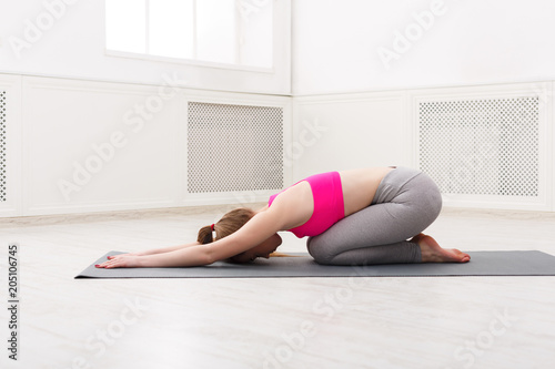 Woman training yoga in child's pose