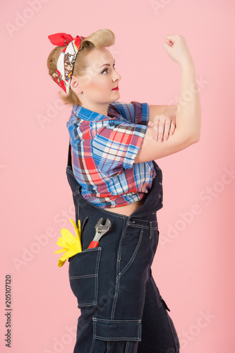 We can do it concept with pin-up vintage style. Blond curls Woman in denim with hand off. Woman power for success.