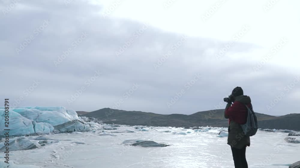 Tourist girl makes a photo of the glacier. Tourist girl makes a photo of the glacier.