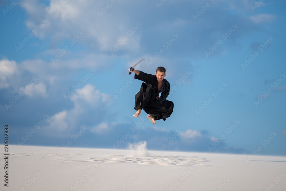 Expressive man jumps with a Japanese sword, katana Expressive man jumps with a Japanese sword, katana