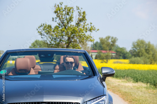 Young woman drive a convertible car on a sunny day © Riko Best