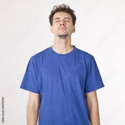 Boy in blue shirt closing eyes photo