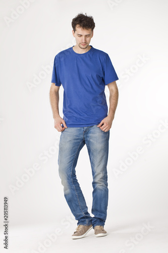 Young man in blue T-shirt standing and looking down