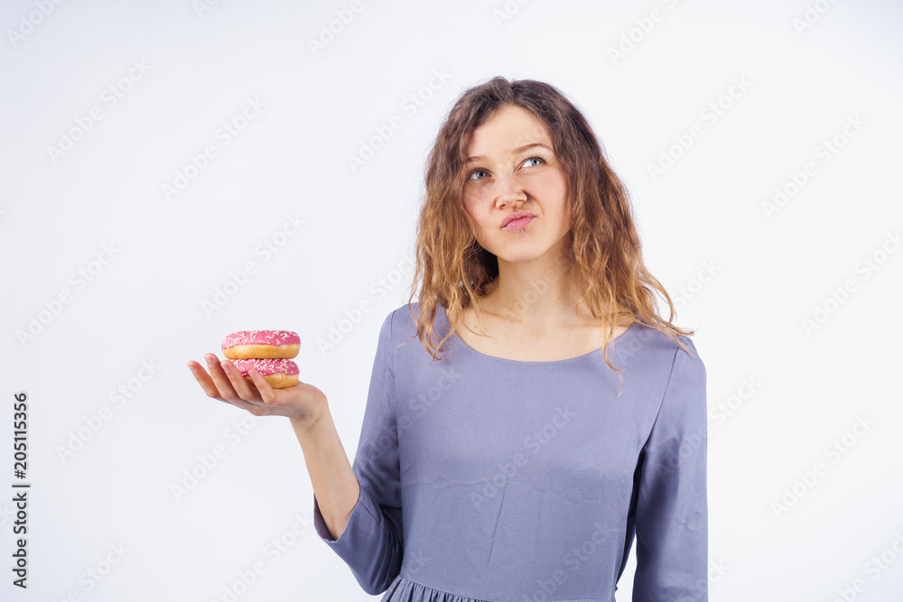 A young woman thinks to eat or not a donut A young woman thinks to eat or not a donut