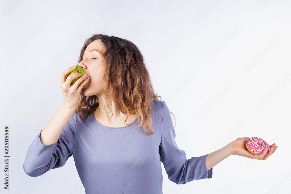 Young woman with pleasure eating apple not donut. Young woman with pleasure eating apple not donut.