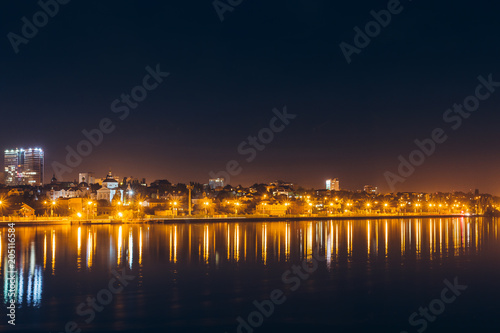 Reflection of night city lights in water or river © DedMityay