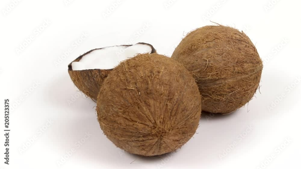 Two whole ripe brown tropical coconuts and a half with yummy white pulp rotating on white isolated background. Healthy fresh tropical fruits. Loopable seamless cocos rotating Two whole ripe brown tropical coconuts and a half with yummy white pulp rotating on white isolated background. Healthy fresh tropical fruits. Loopable seamless cocos rotating