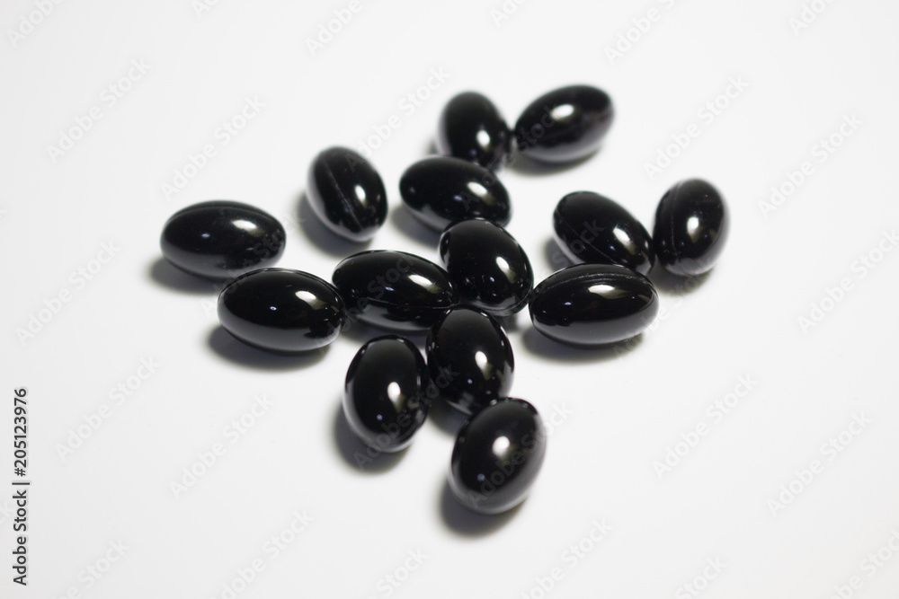 Black supplement capsule on white background Black supplement capsule on white background