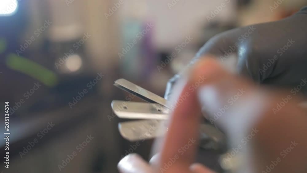 Barber adjusting razors, close up Barber adjusting razors, close up