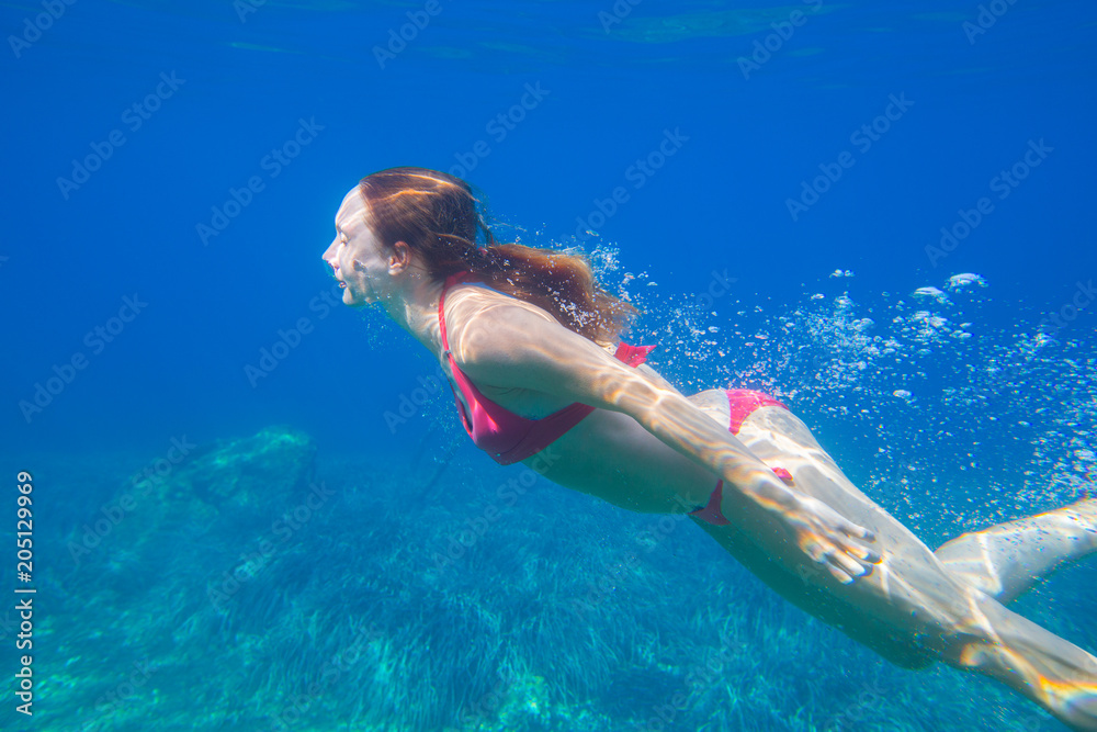 woman swims under water